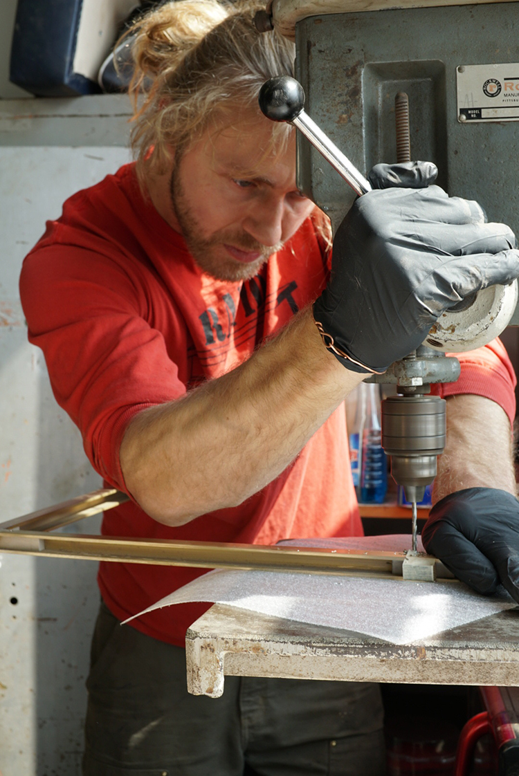 Cam Crockford carefully designs a sleek, modern metal component for a custom furniture piece.